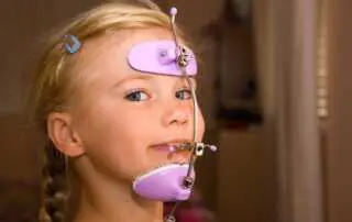 a girl wearing purple pull reverse headgear braces in Richmond, TX