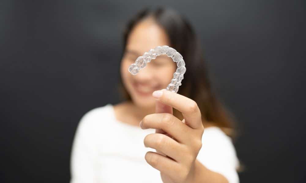 woman holding Clear Aligners