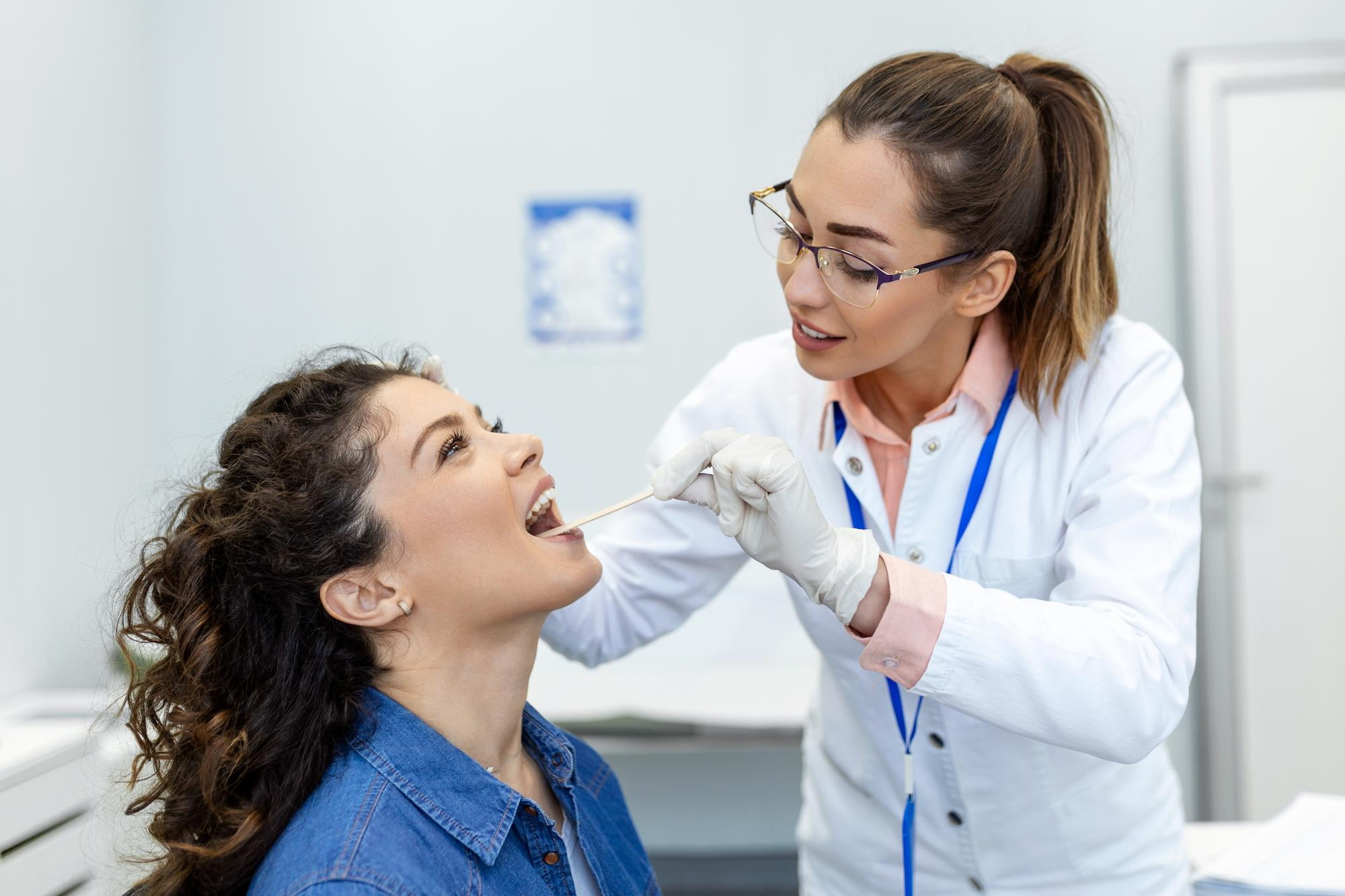 Female orthodontist examining patient's mouth and airway in modern clinic, demonstrating sleep apnea treatment and airway improvement benefits at Elara Orthodontics in Richmond and Houston, TX.
