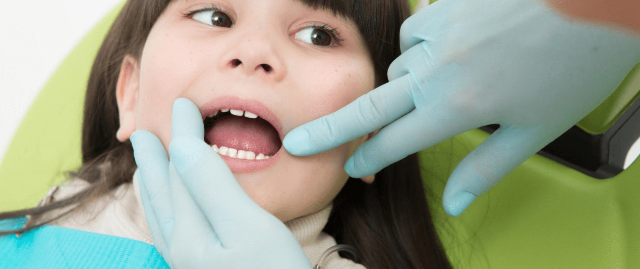 At Elara Orthodontics in Richmond or Houston, TX, a children’s orthodontist gently examines a child's teeth while she sits in the dental chair.