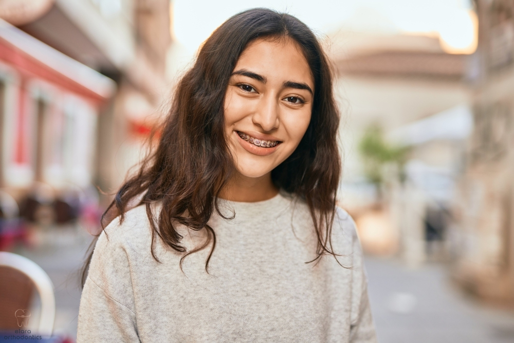 young middle east girl with metal braces smiling happy - Retainer vs Braces in Houston and Richmond, TX